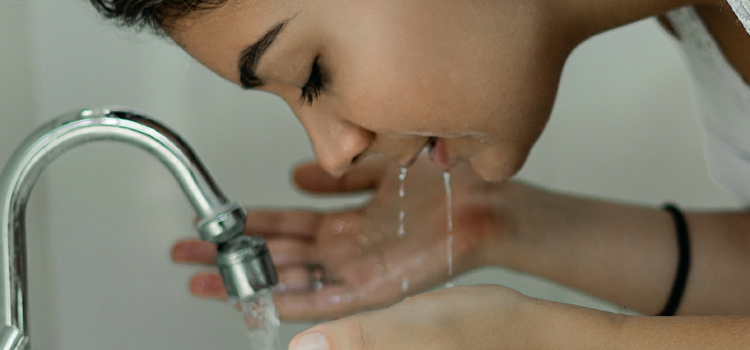 girl washing his face on water