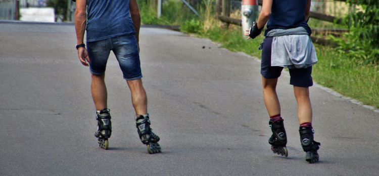 two mens are skating in the road